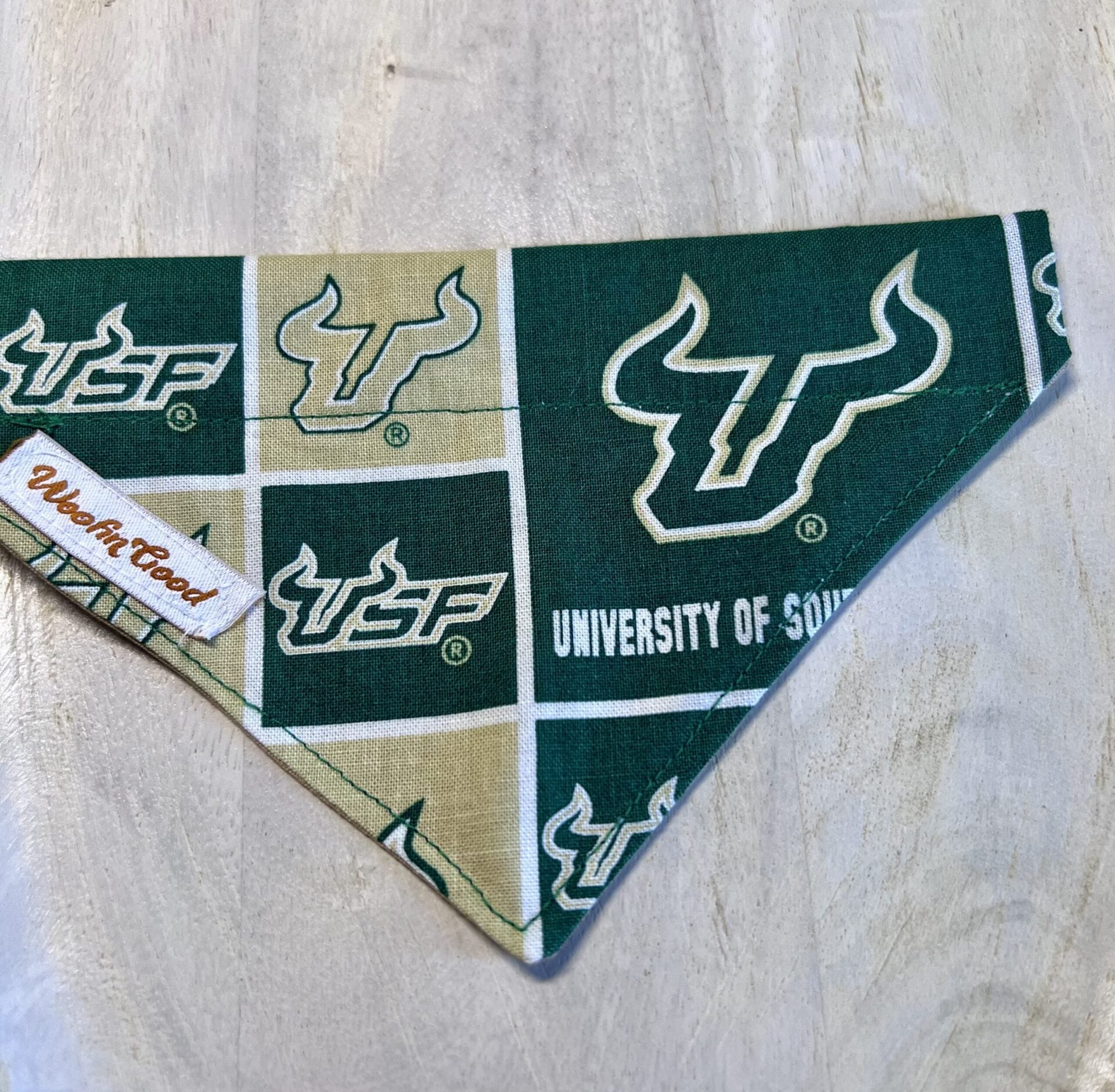 Dog bandana with South Florida Bulls logo on a wooden surface