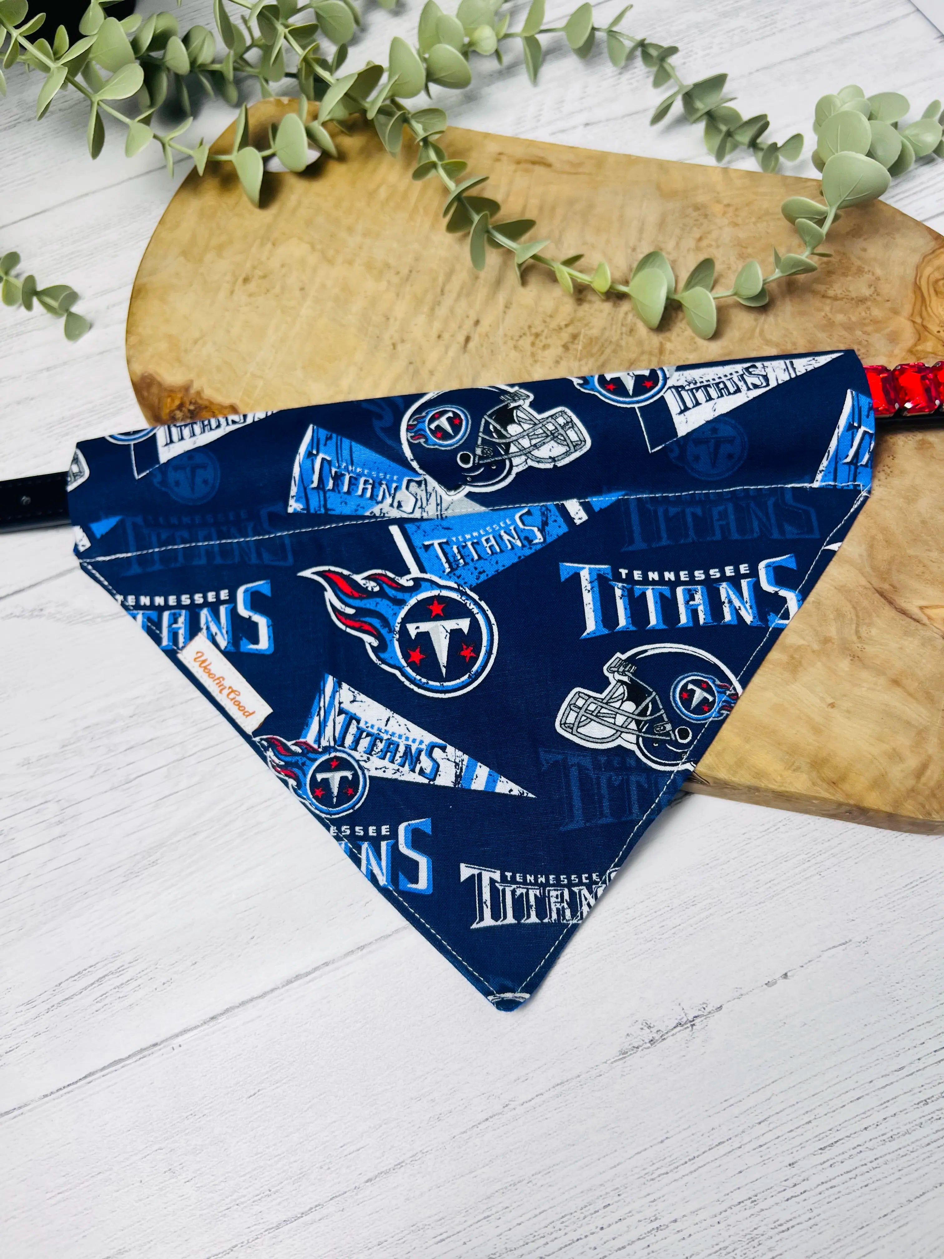 Blue patterned fabric triangle on a wooden paddle with eucalyptus leaves on a white wooden surface